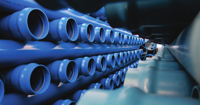 Stacked blue PVC pipes in a warehouse